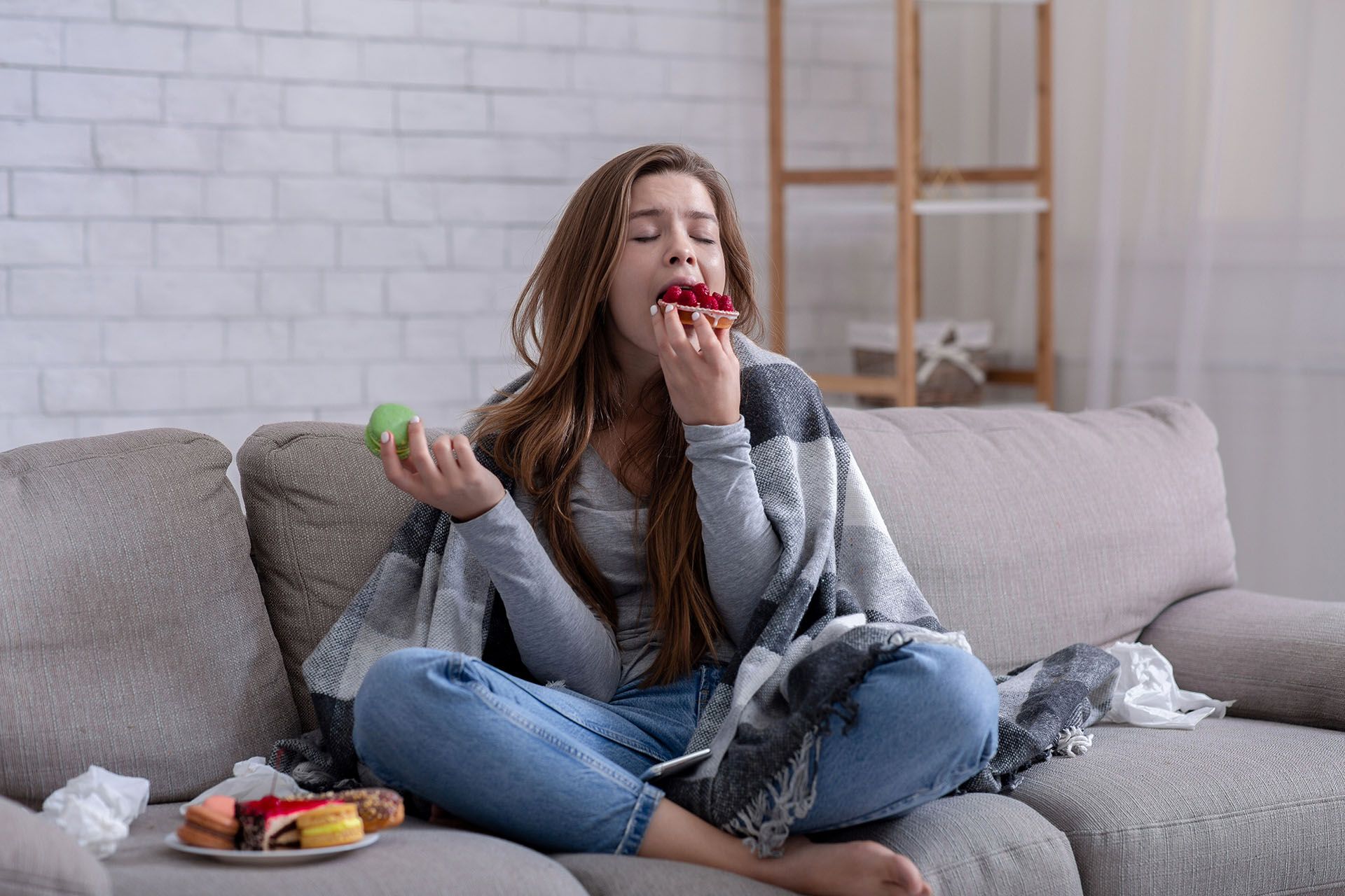 woman eating on a couch