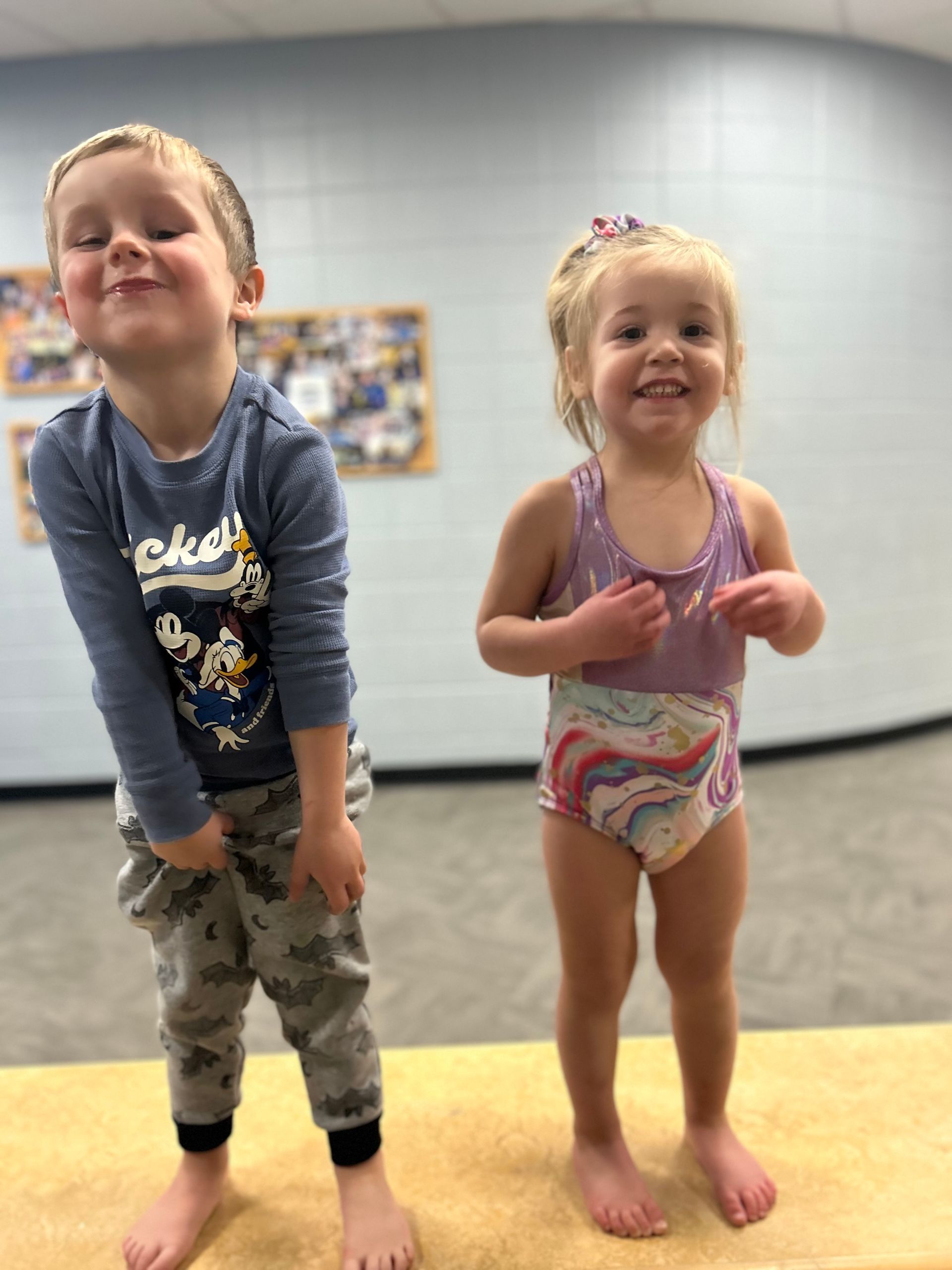 A boy and a girl are standing next to each other on a table.