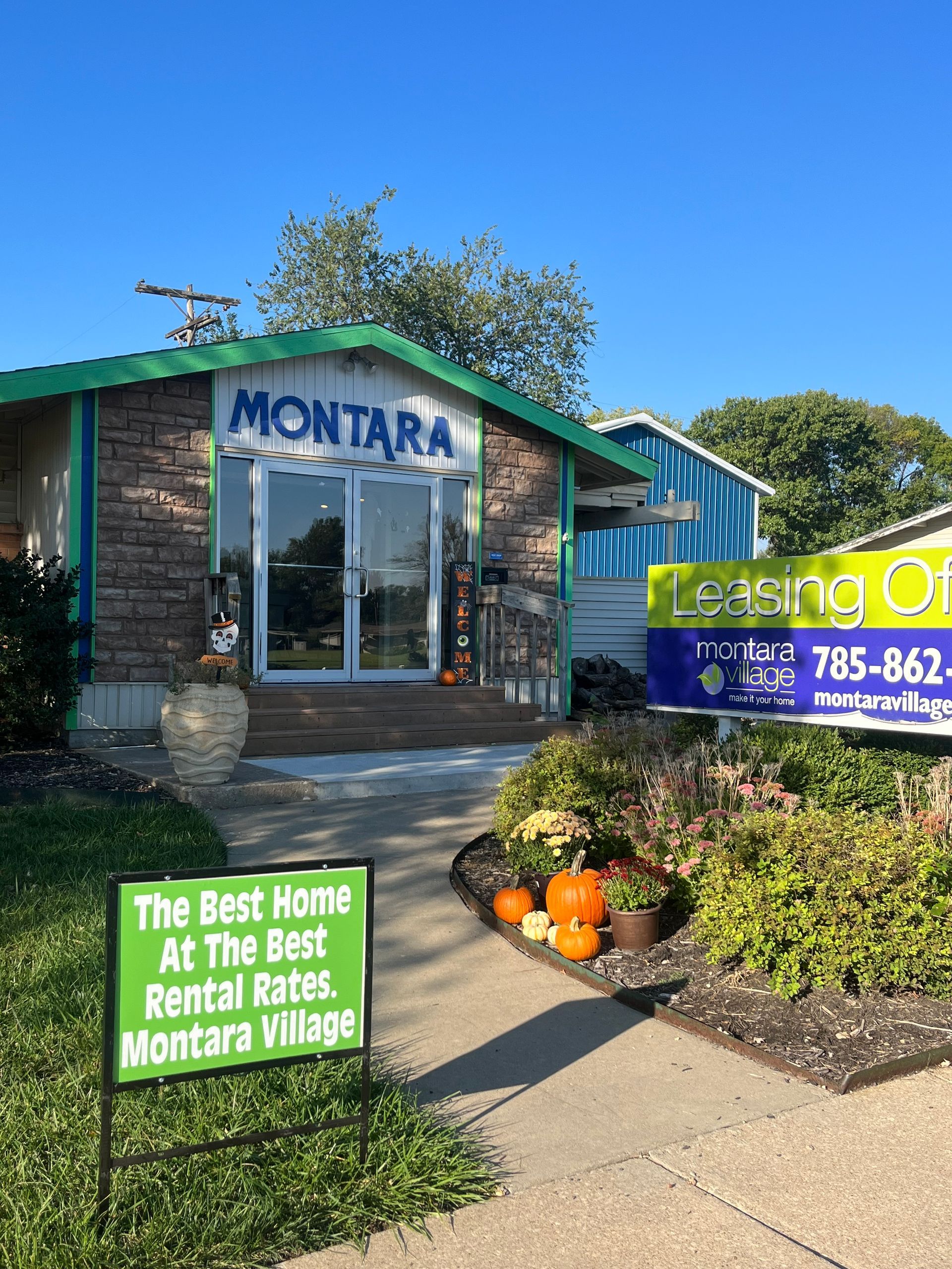Montara Village leasing office with sign, pumpkins, and a green roof.