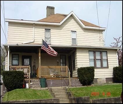 A house with an american flag on the porch.