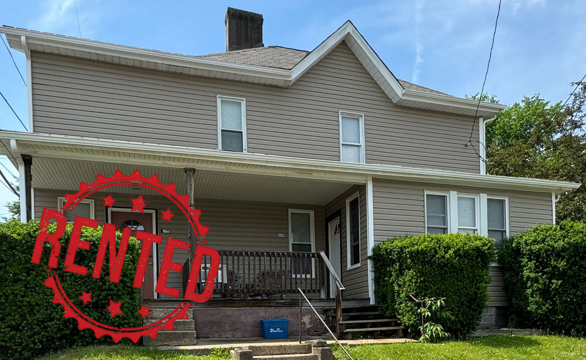 A large house with stairs leading up to the front porch