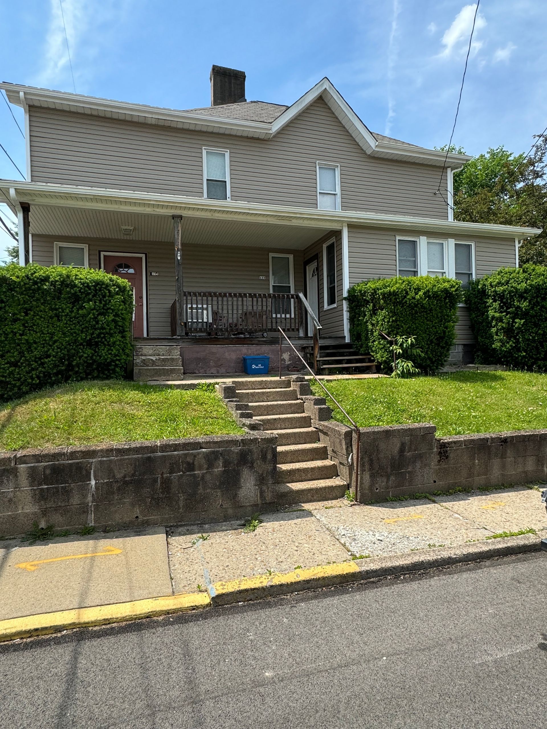 A large house with stairs leading up to the front porch