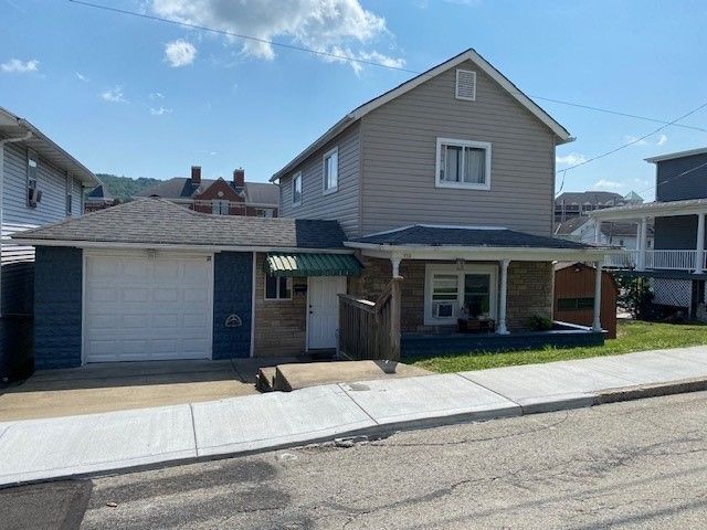 A house with a garage and a porch on a sunny day.