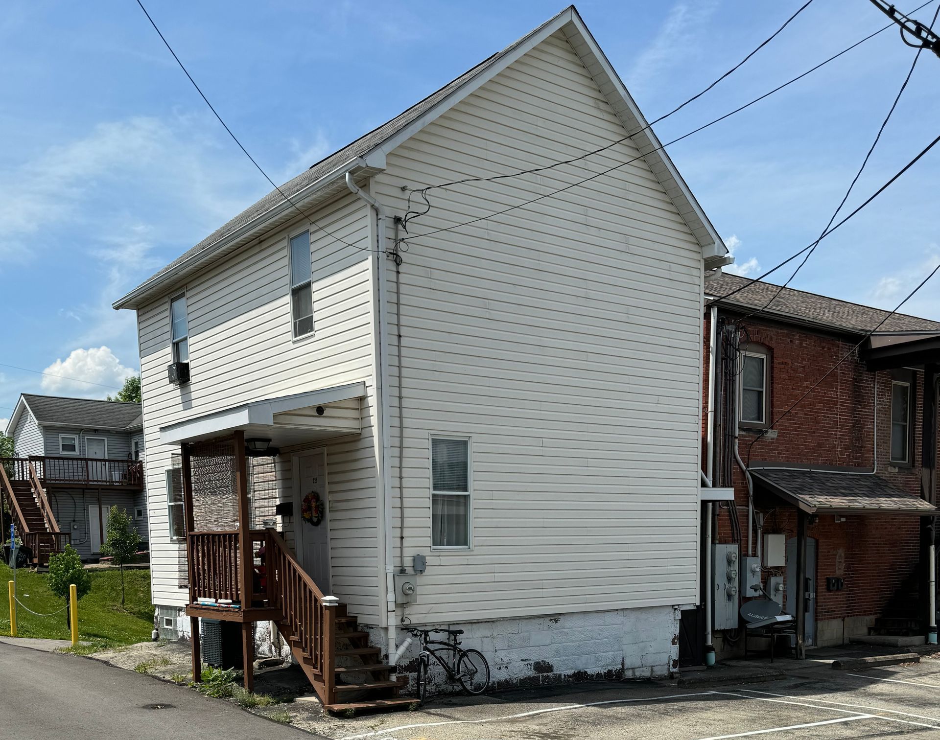 A white house with a bicycle parked in front of it