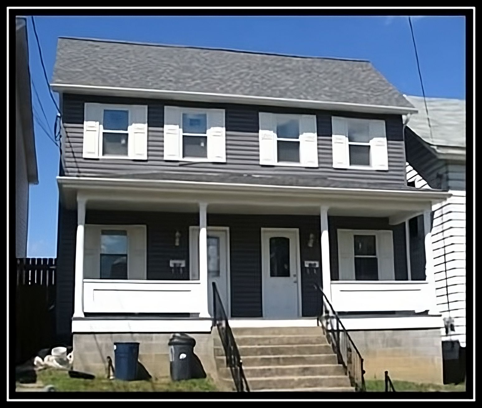 A black house with white shutters and stairs