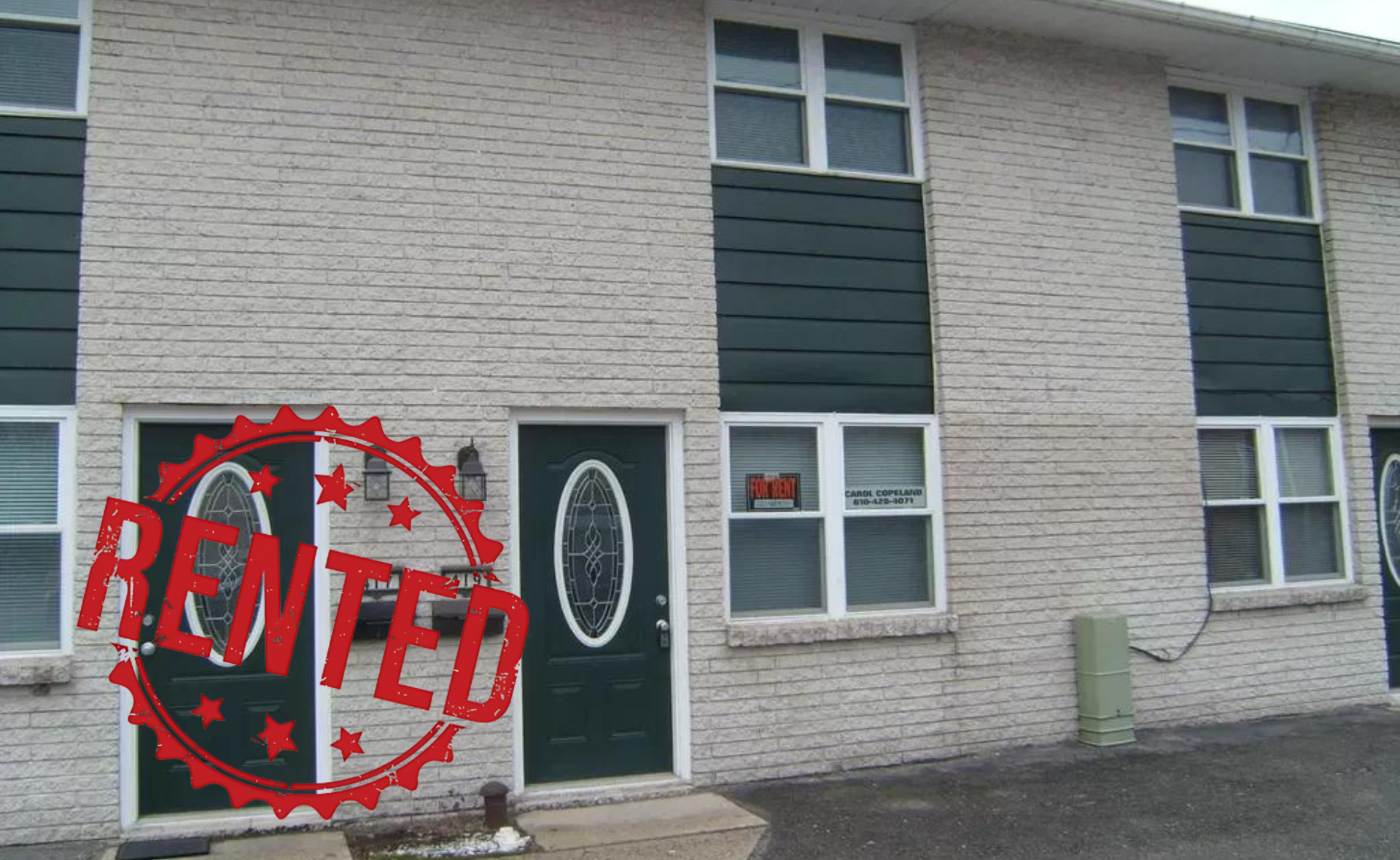 A white brick building with green doors and windows