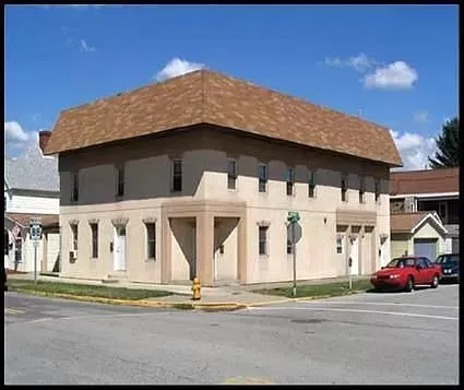 A large building with a red car parked in front of it