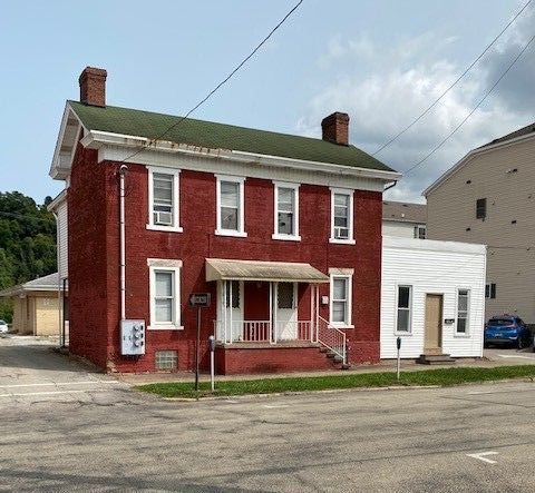 A large red brick house with a green roof