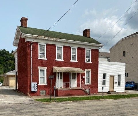 A large red brick house with a green roof