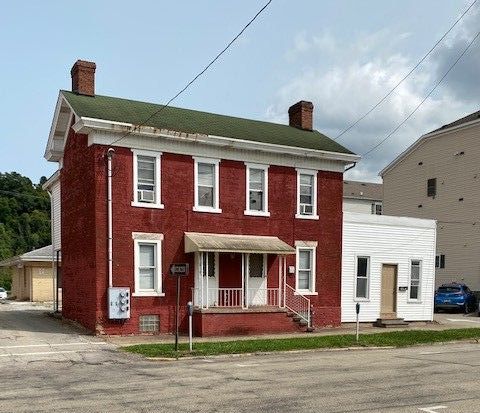 A large red brick house with a green roof