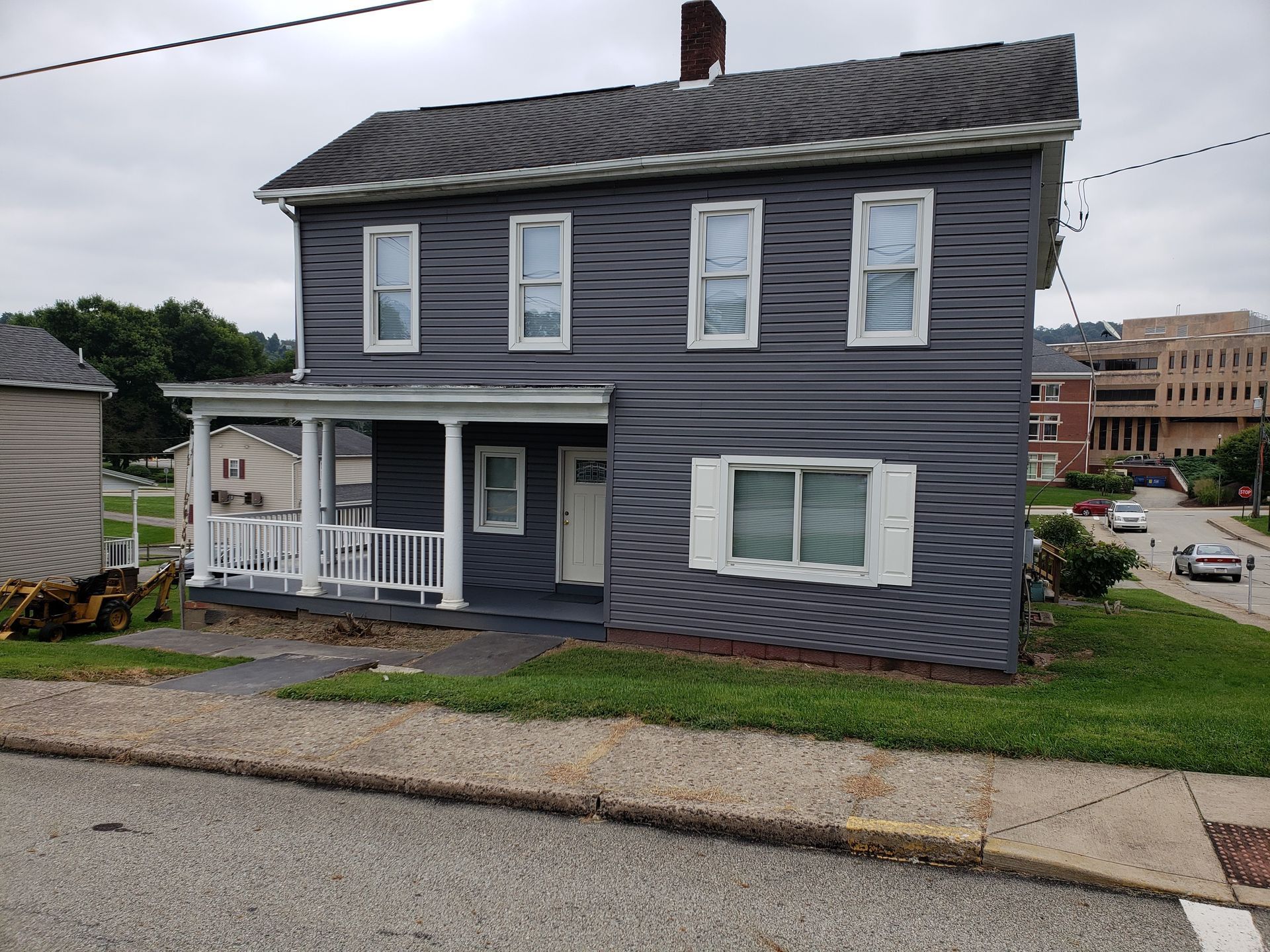 A gray house with white shutters and a porch