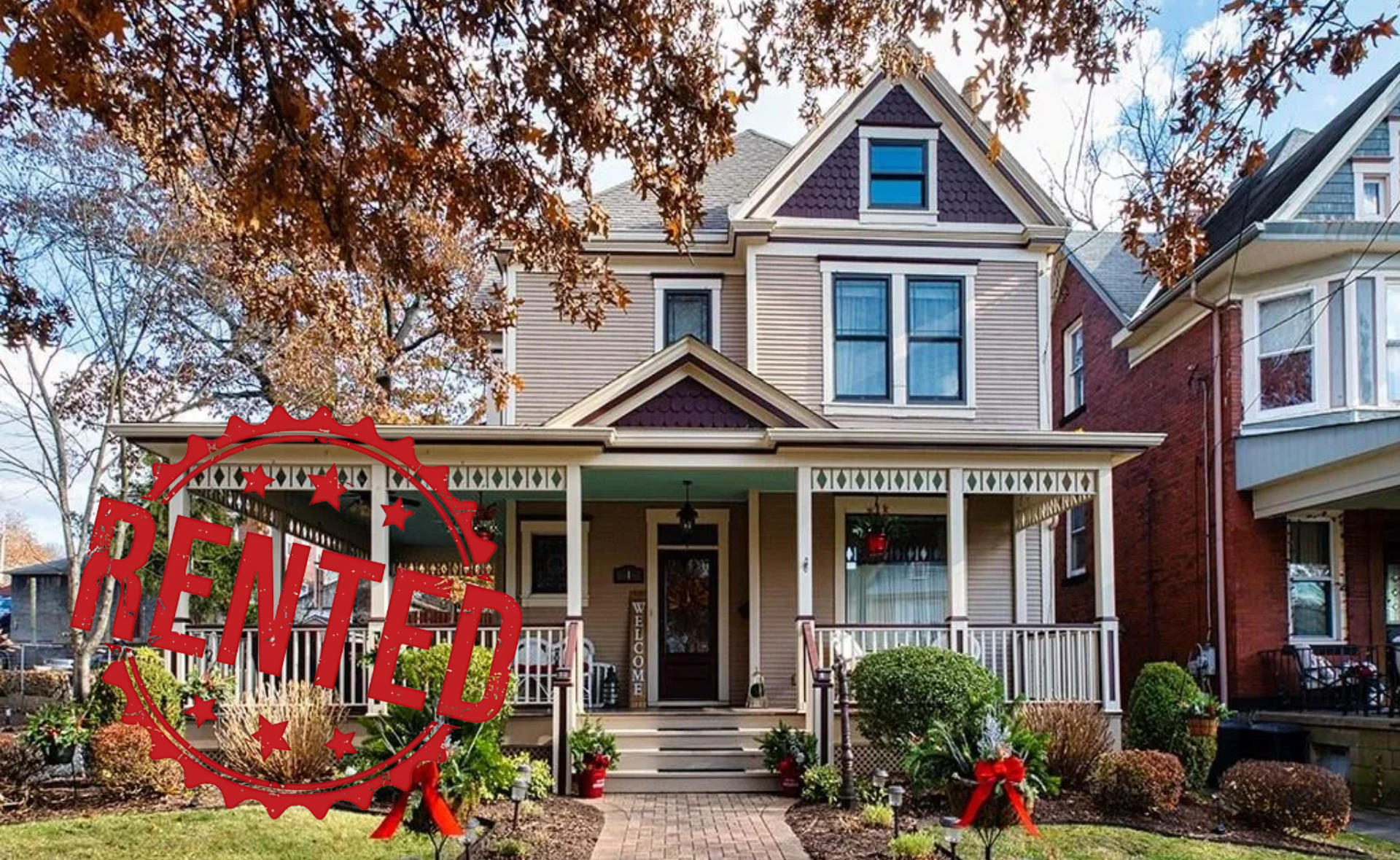 A large house with a large porch is decorated for christmas.