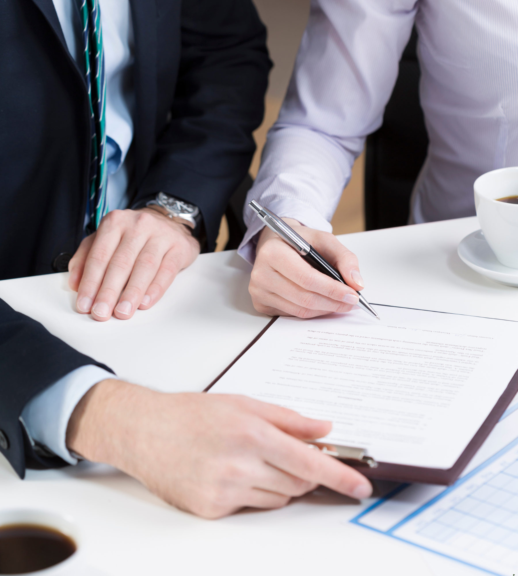 A man in a suit is writing on a piece of paper