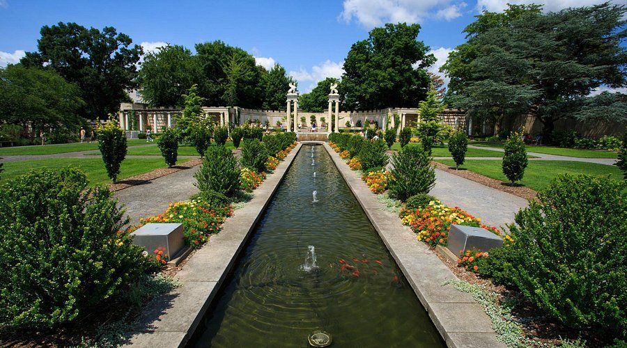 A long pond with a fountain in the middle of it