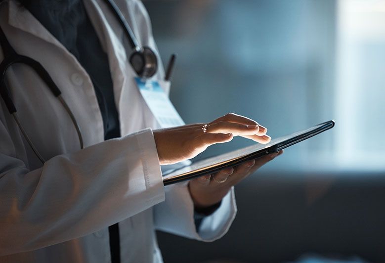 A doctor is using a tablet computer in a hospital.