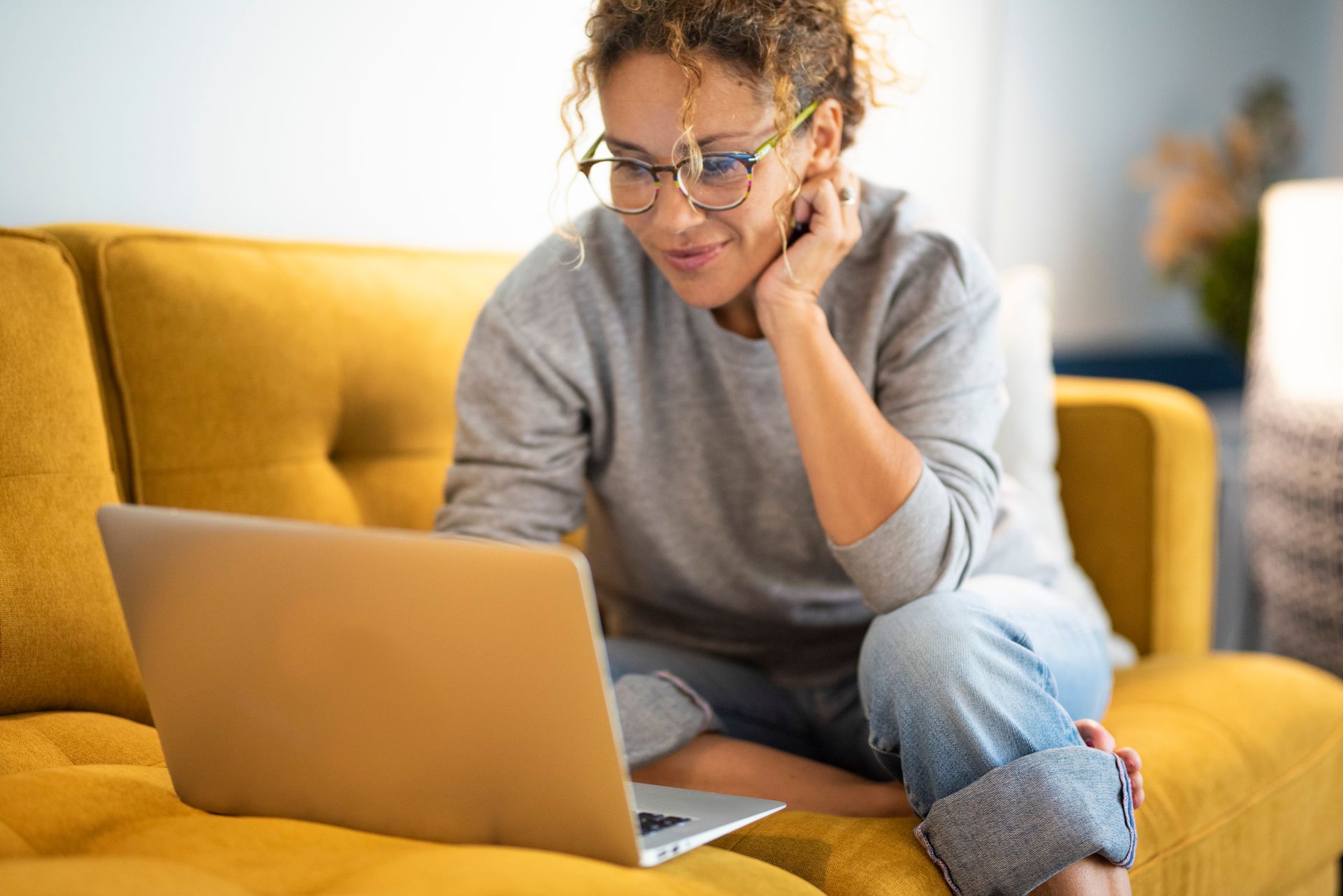 Person at home on the sofa looking for a doctor on google or asking questions of an AI chatbot