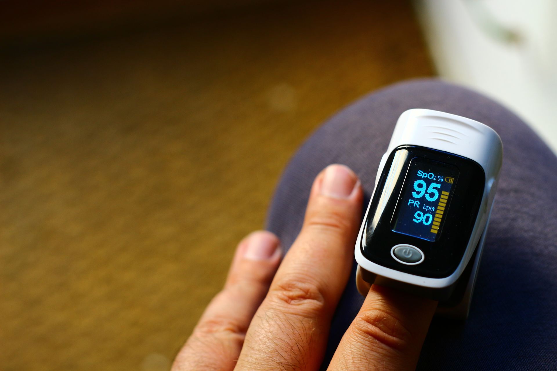 A person 's finger with a pulse oximeter on it that reads 95