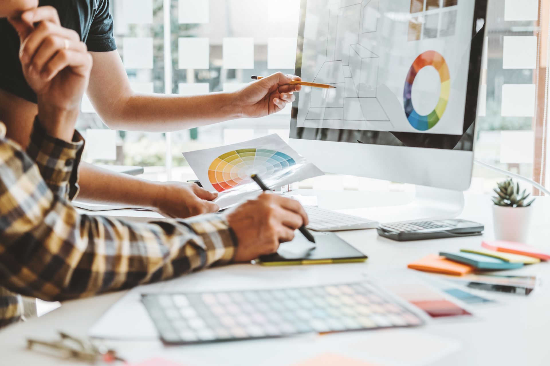 A group of people are sitting at a table working on a computer.