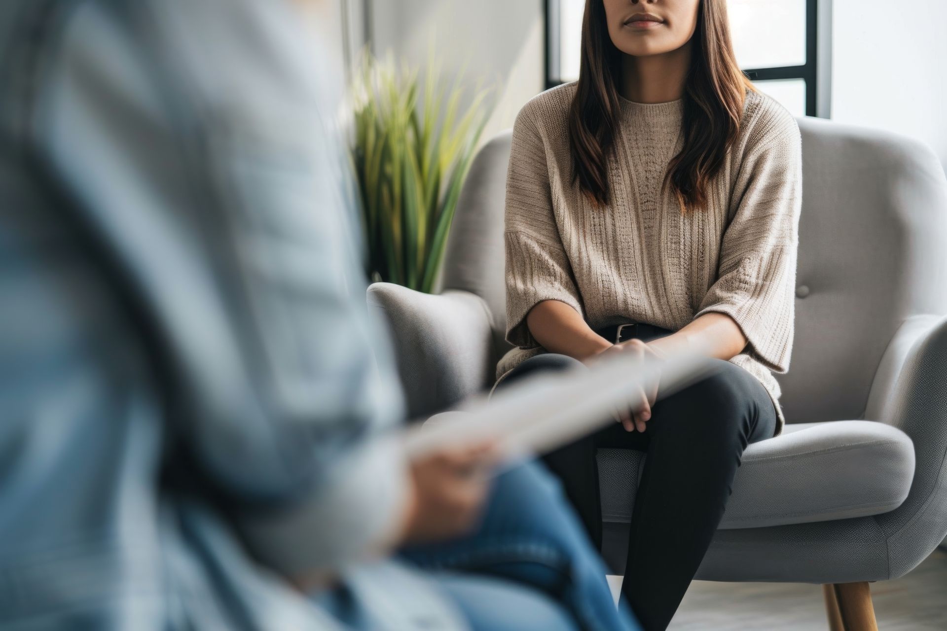 A woman is sitting in a chair talking to a man.