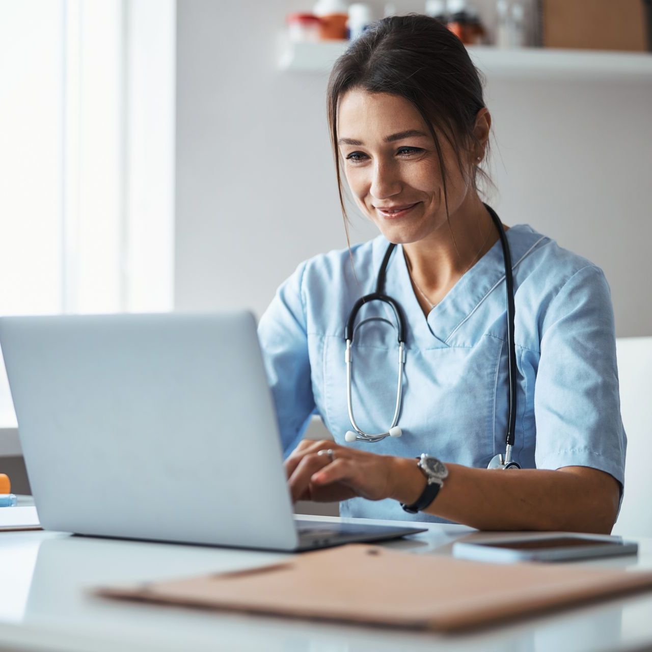 Female doctor looking at her website on a laptop