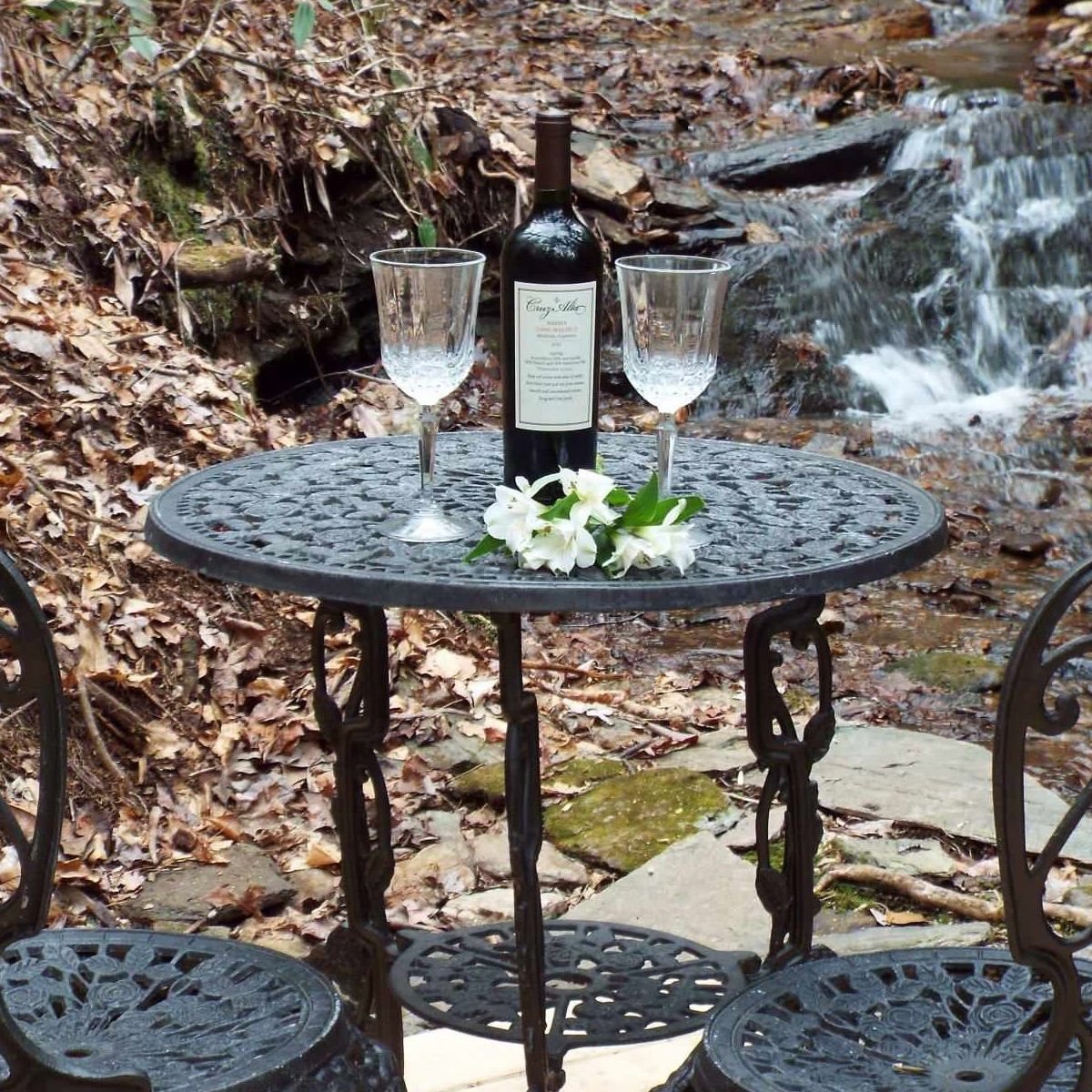 A table with a bottle of wine and two glasses on it