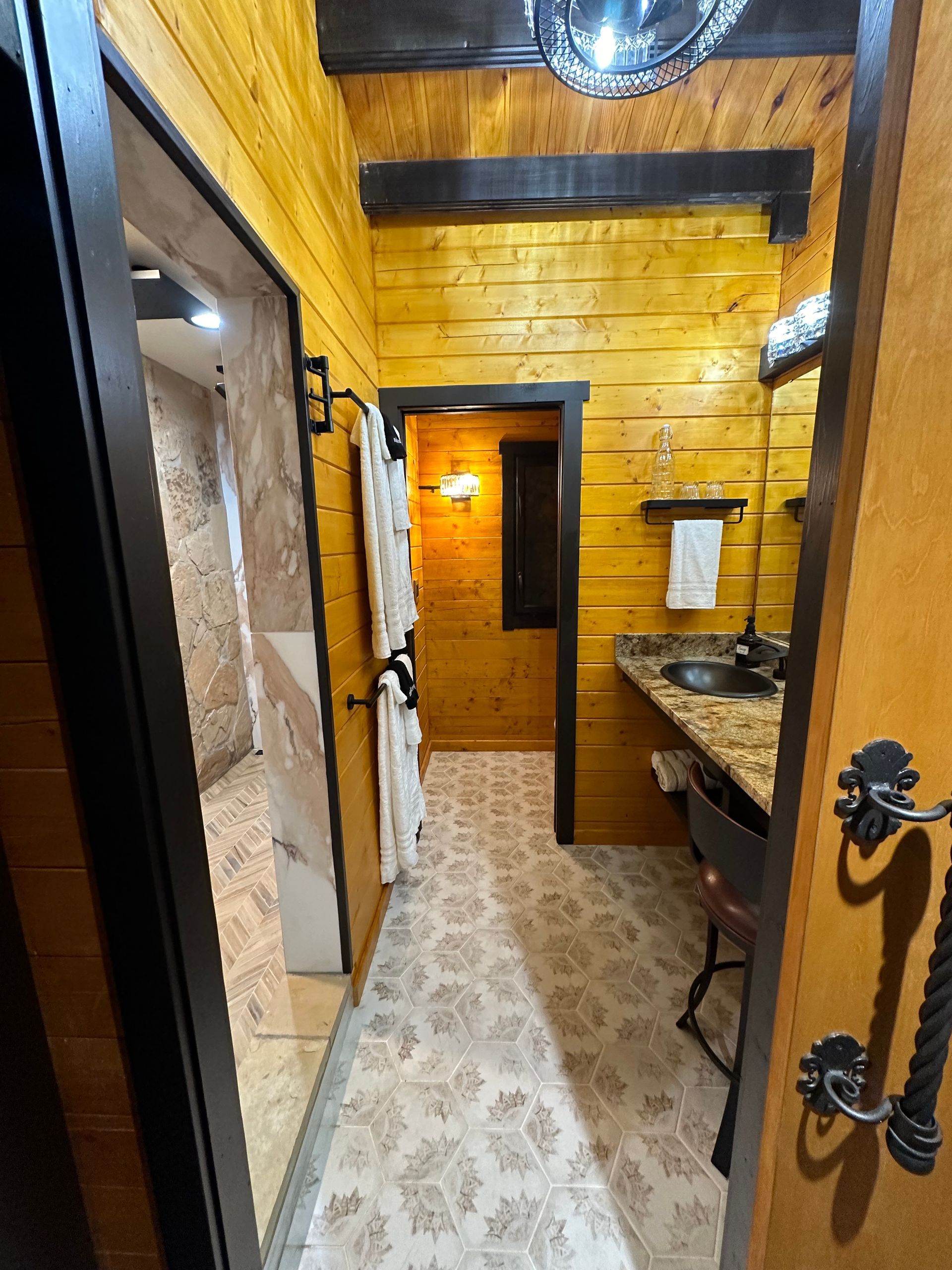 A hallway leading to a bathroom in a log cabin.