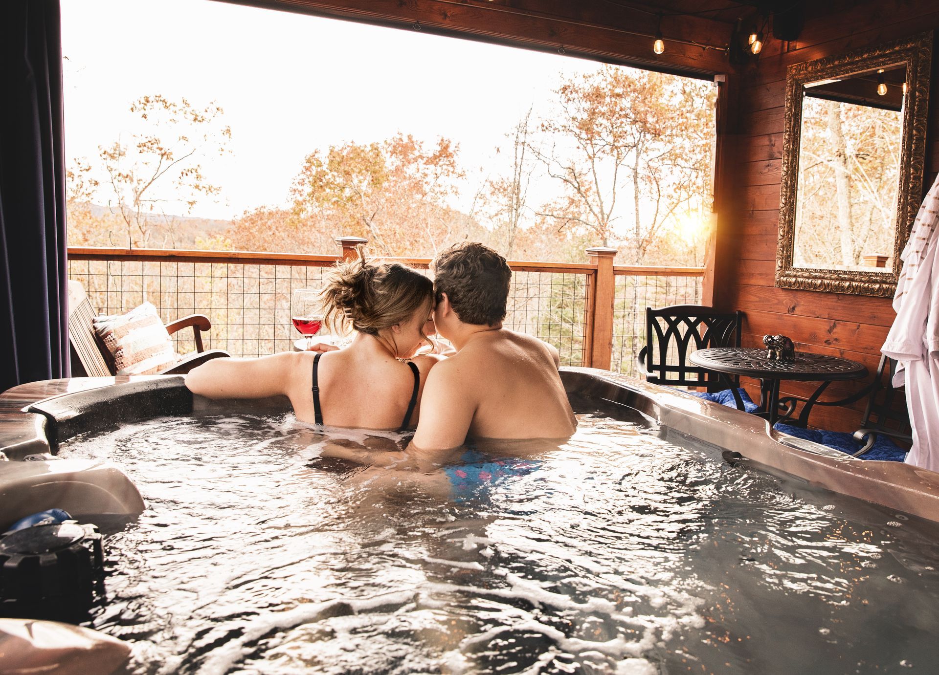 A man and a woman are kissing in a hot tub.