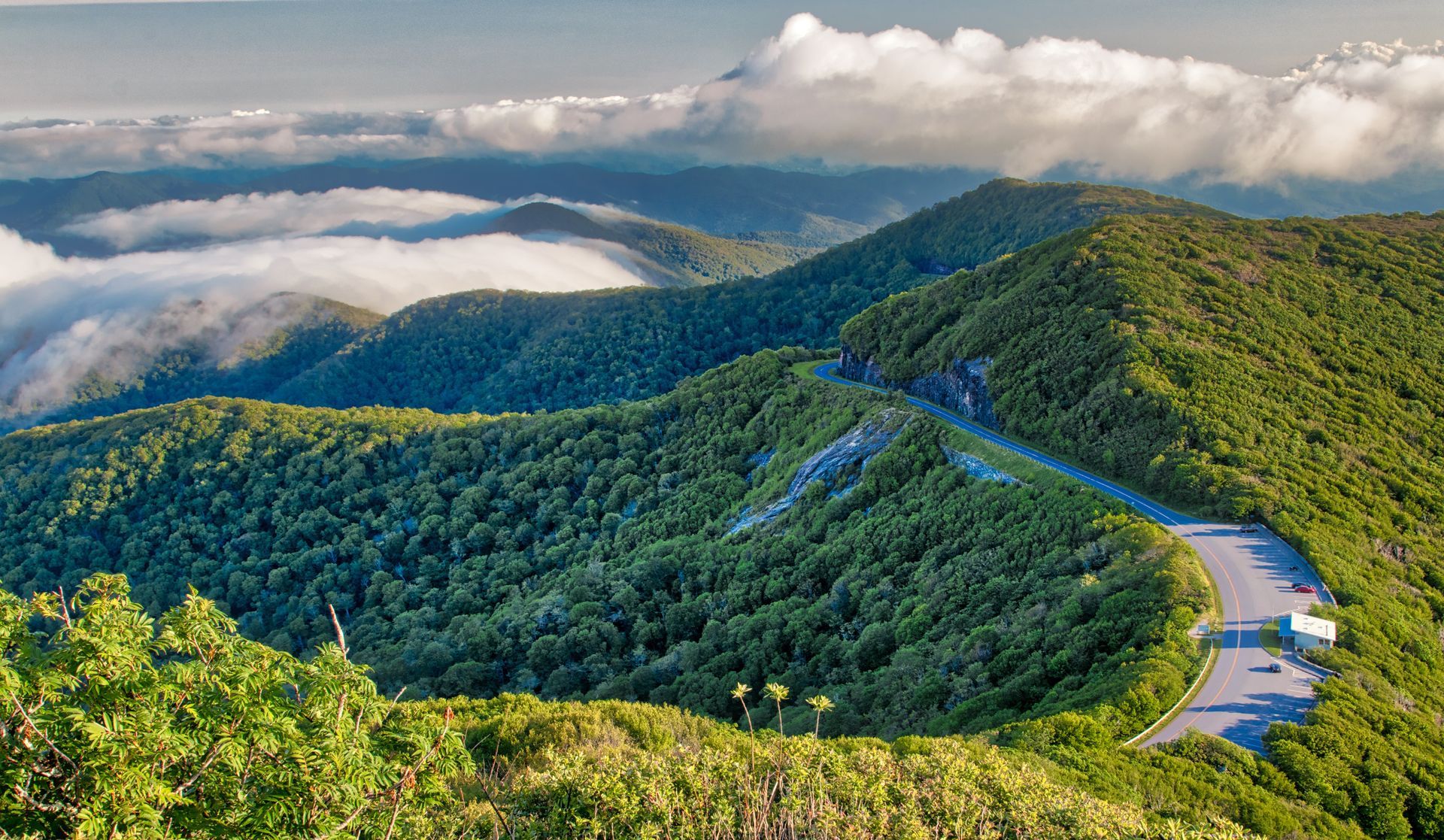 An aerial view of a mountain range with a road going through it.
