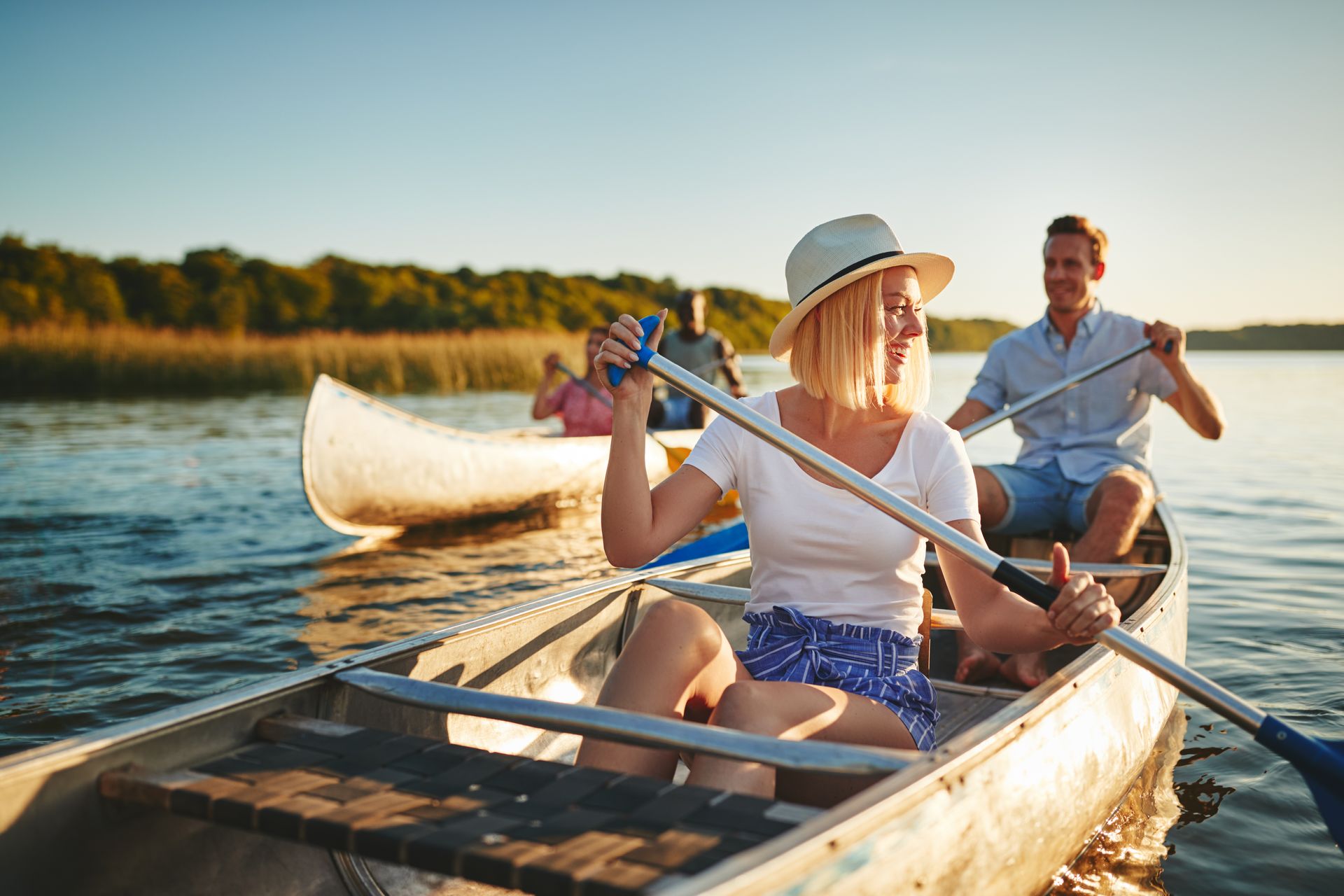 A group of people are rowing a canoe on a lake.