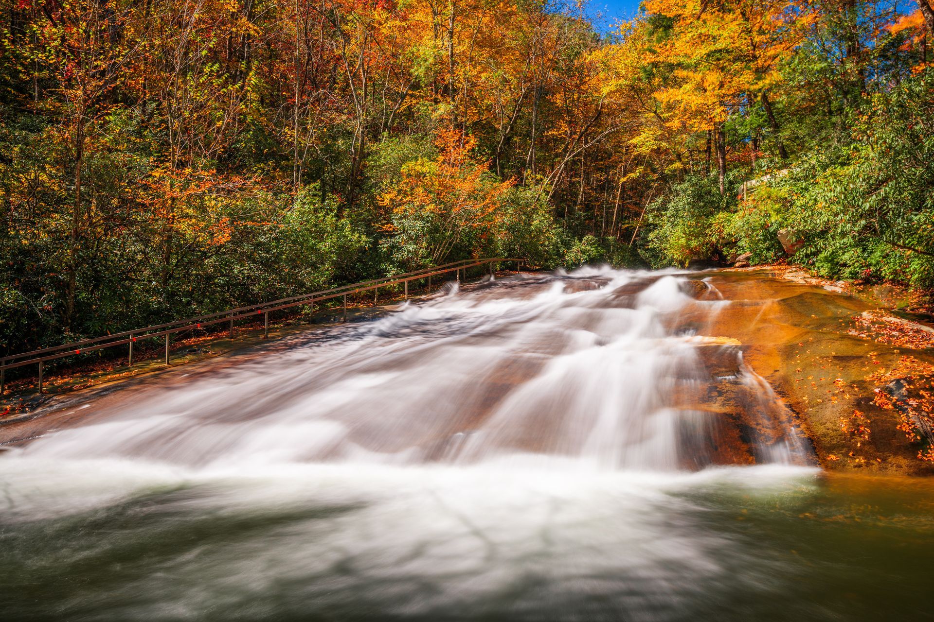 A waterfall in the middle of a forest in autumn