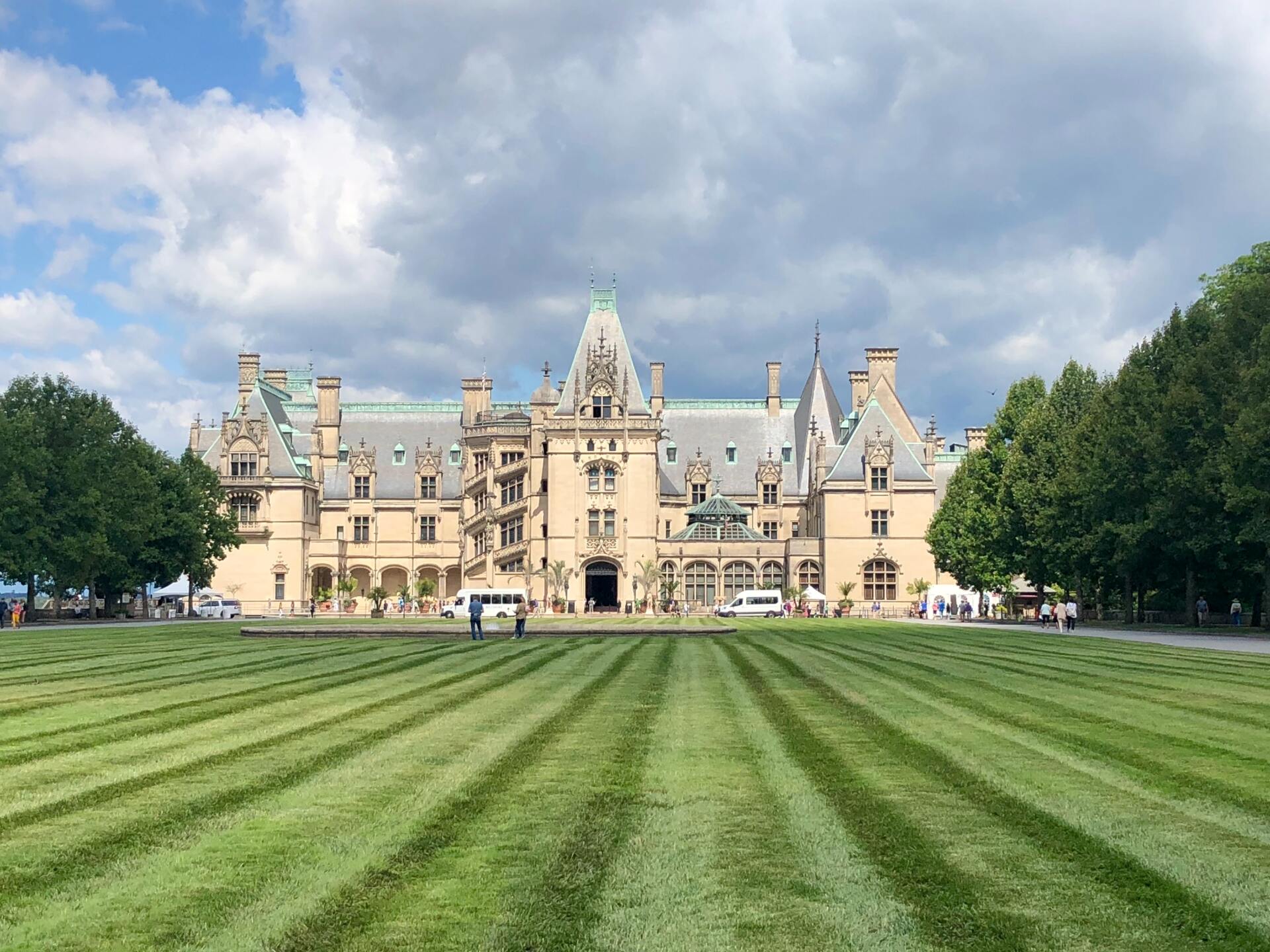 a large castle with a lush green lawn in front of it .