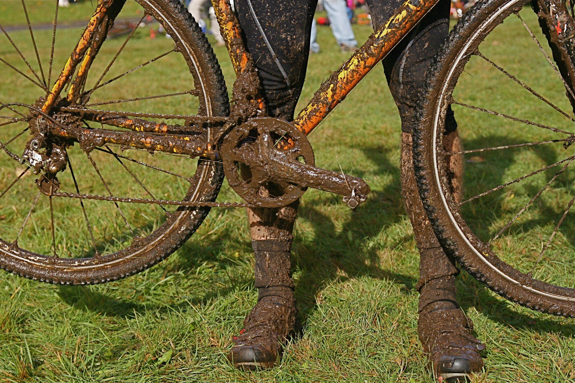 a person is standing next to a muddy bicycle