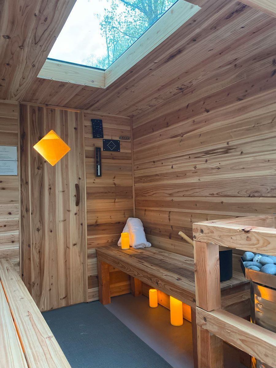 A wooden sauna with a skylight and a bench.