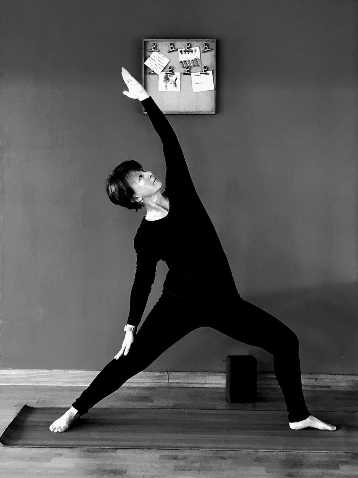 A silhouette of a person sitting in a lotus position with the sun behind them.