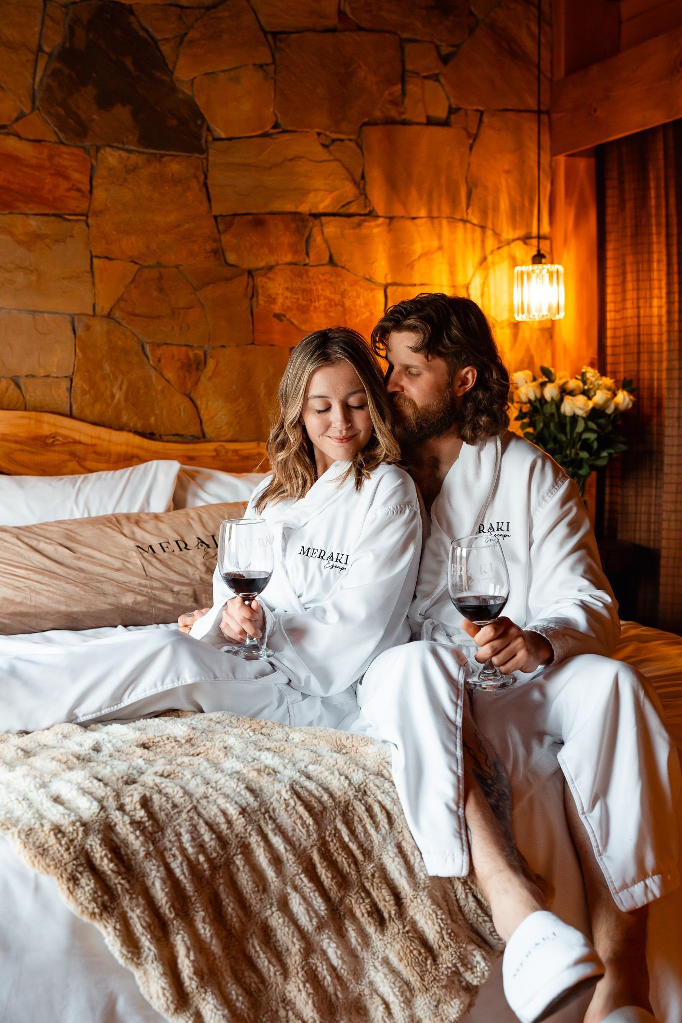 A man and a woman are sitting in a hot tub holding wine glasses.