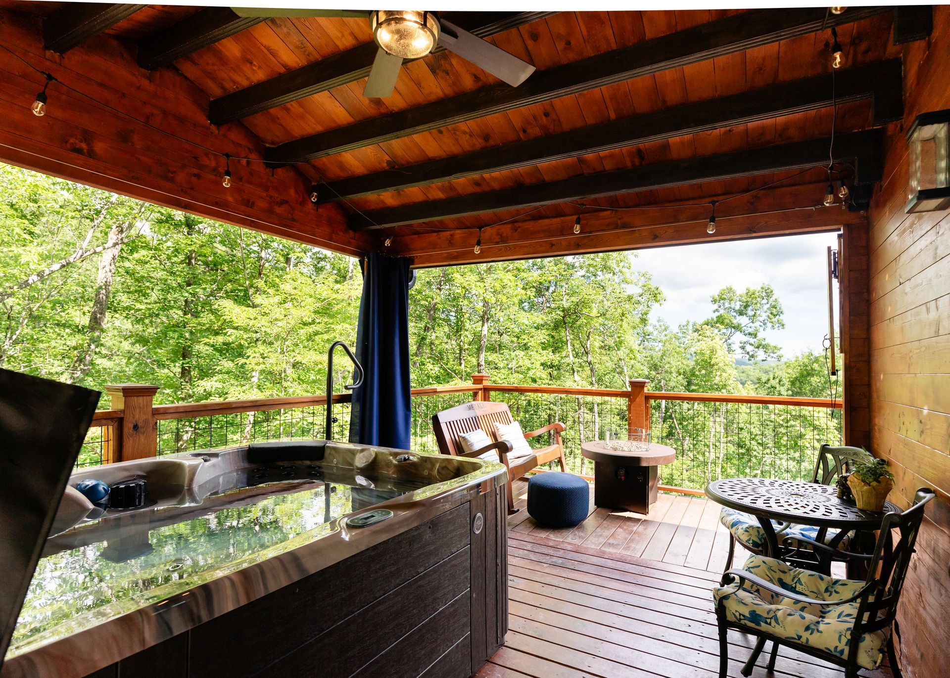 There is a hot tub on the deck with a table and chairs.