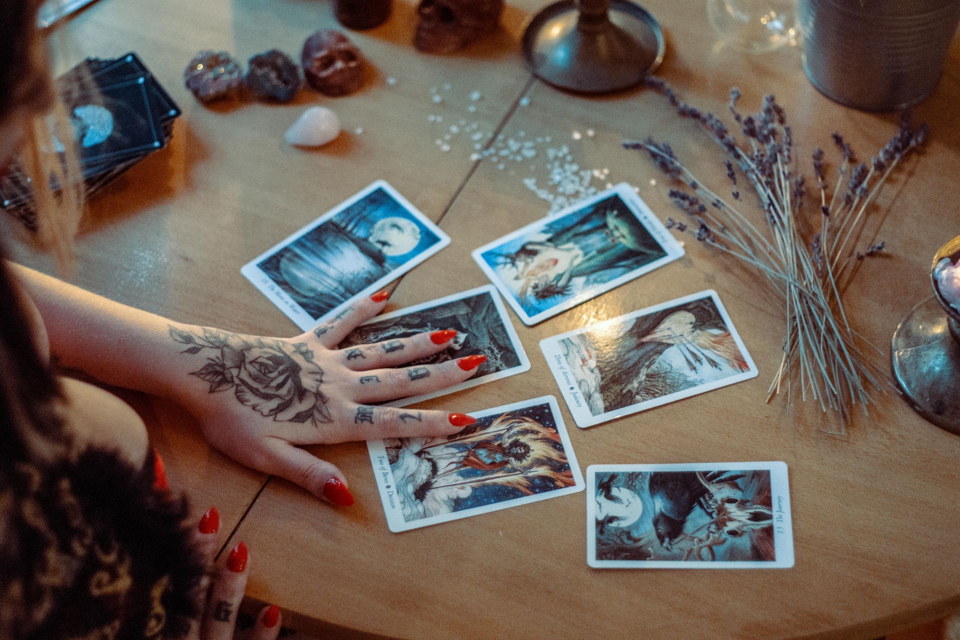 A woman is sitting at a table playing tarot cards.