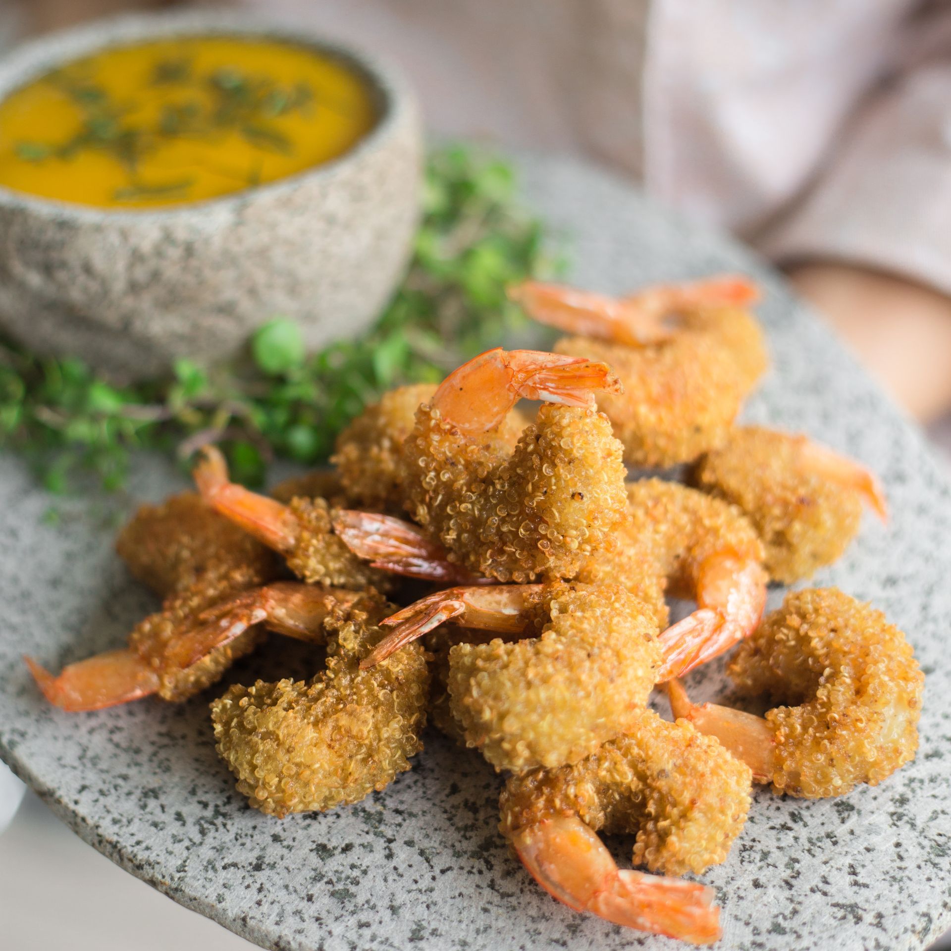 a plate of fried shrimp next to a bowl of dipping sauce .