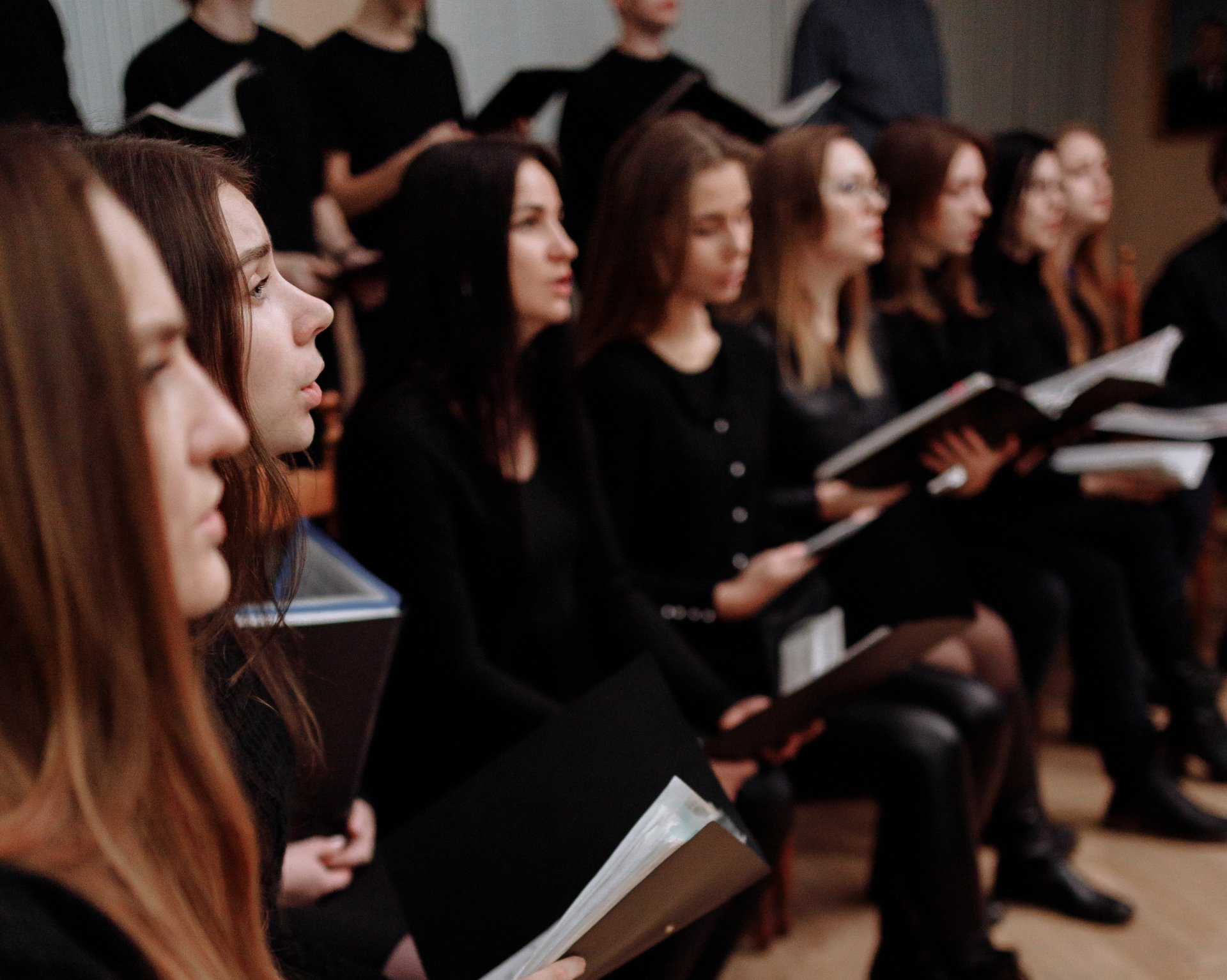 a group of people are sitting in a choir singing .