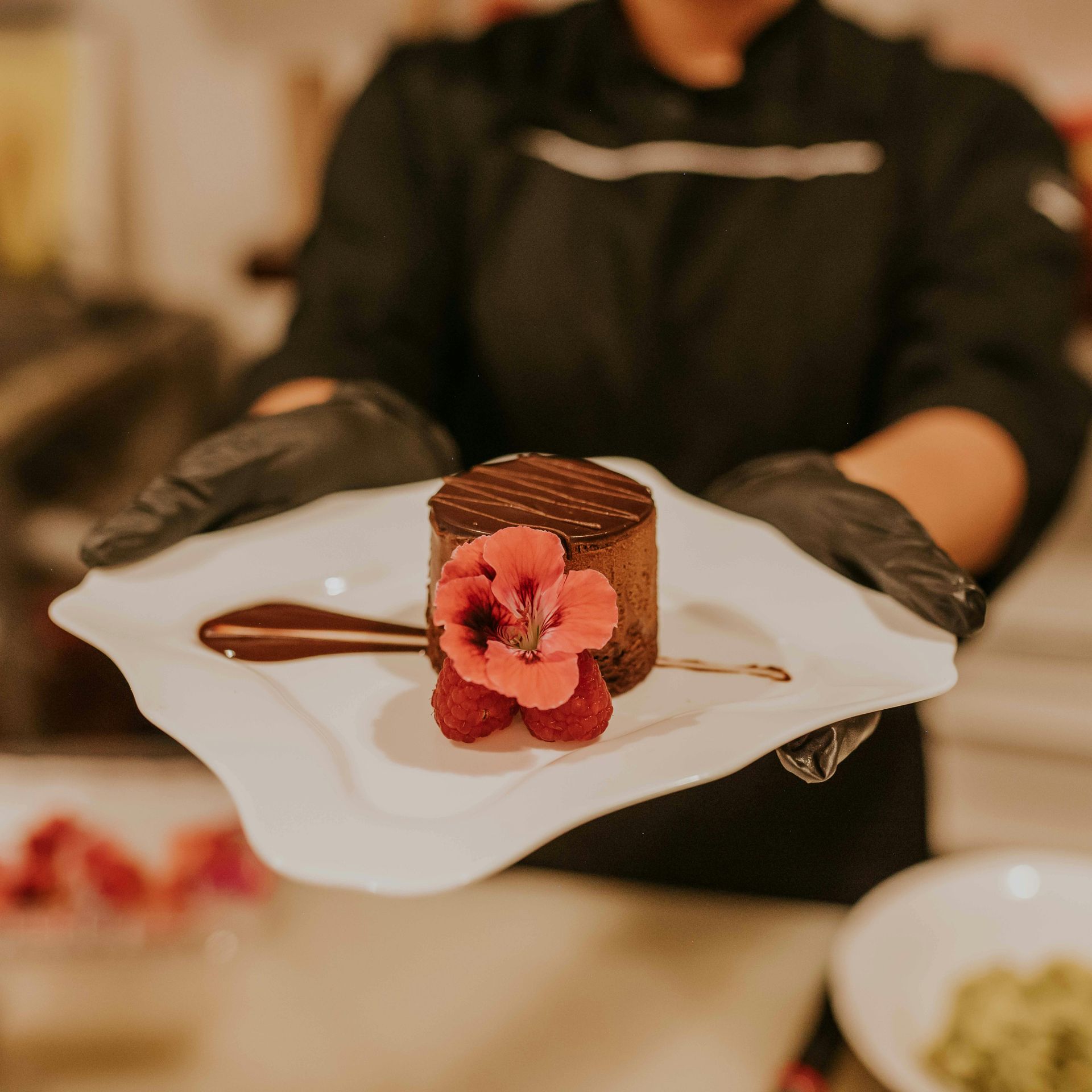 A chef is preparing a plate of food in a kitchen.