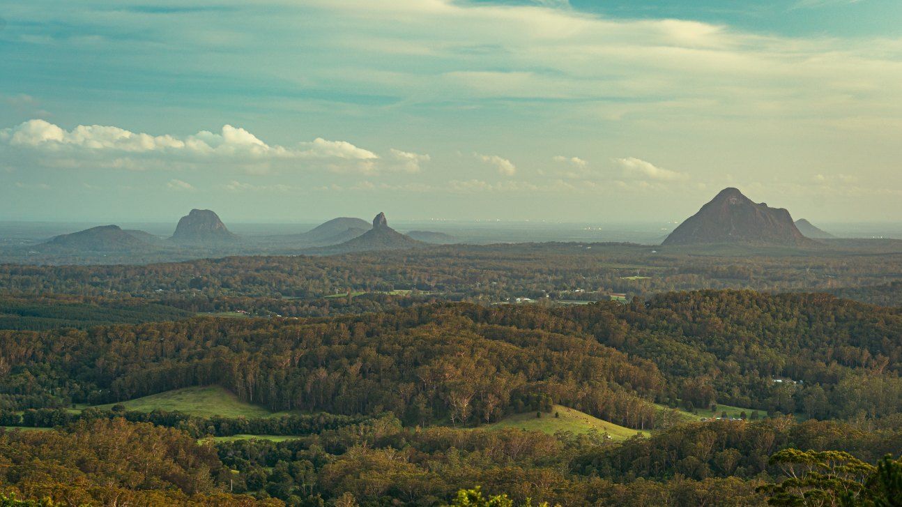 A View of a Valley With Mountains in the Distance and Trees in the Foreground — Action Air N Elec in Palmwoods, QLD