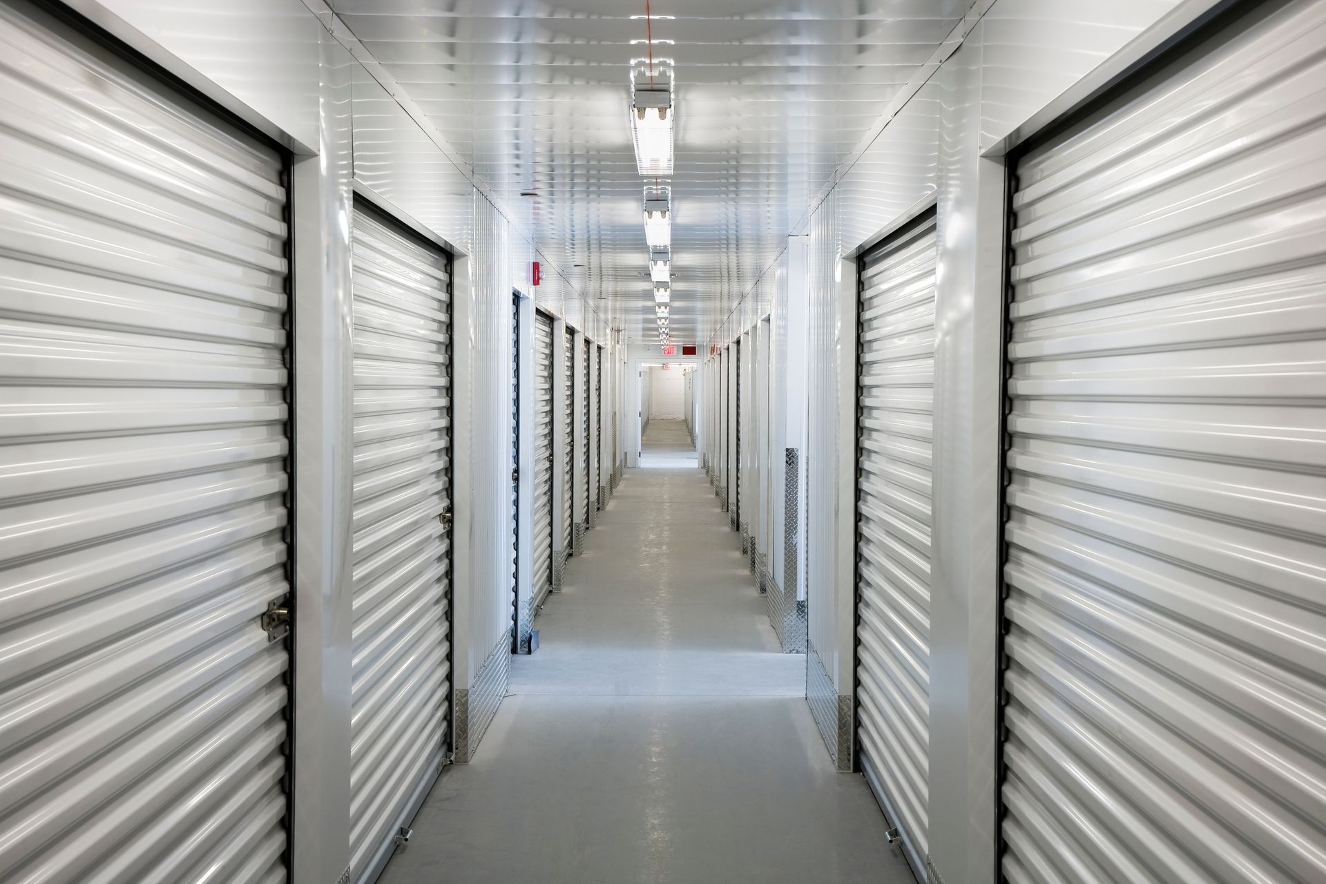 Interior of storage unit hallway with multiple unit doors.