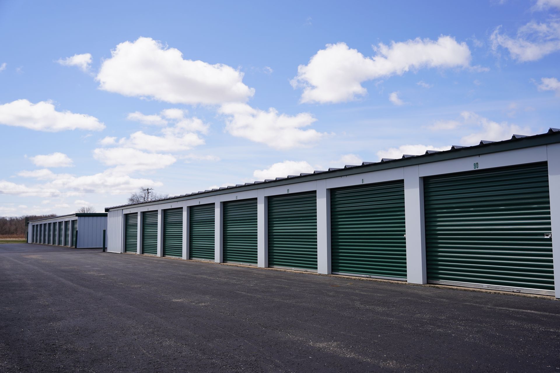 Person unlocking an orange storage unit door with a key.
