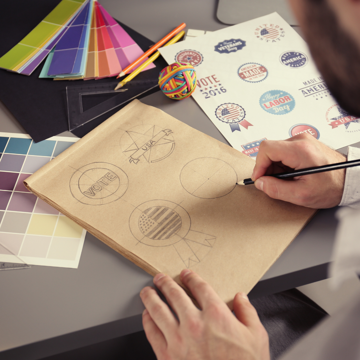 A man is drawing on a piece of paper that says vote 2016