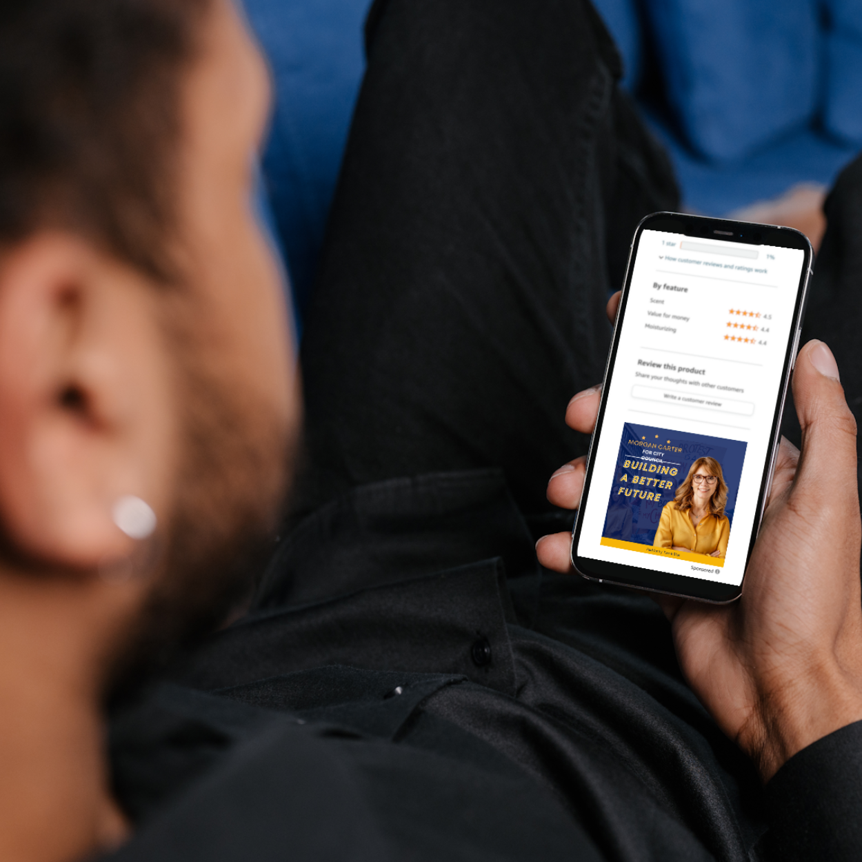 A man is laying on a couch holding a cell phone.