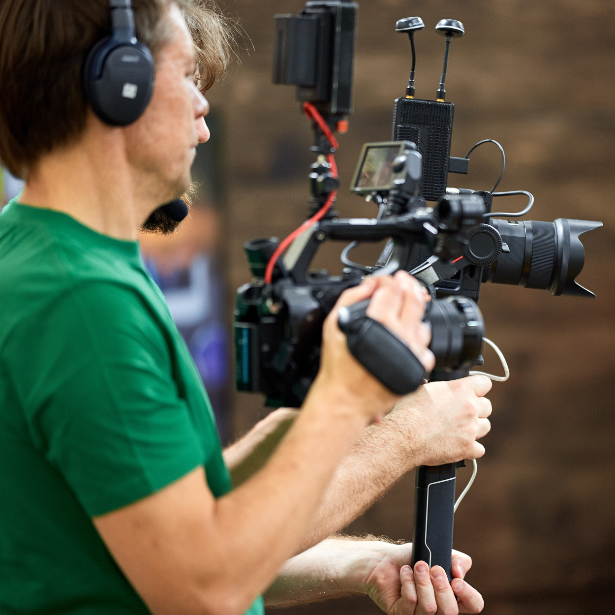 A man wearing headphones is holding a camera