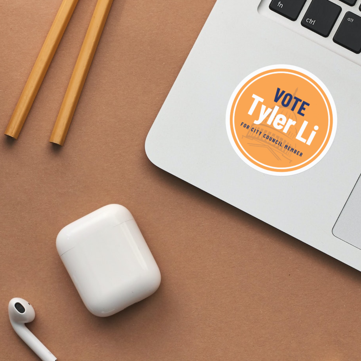 A laptop with a vote tyler li sticker on it