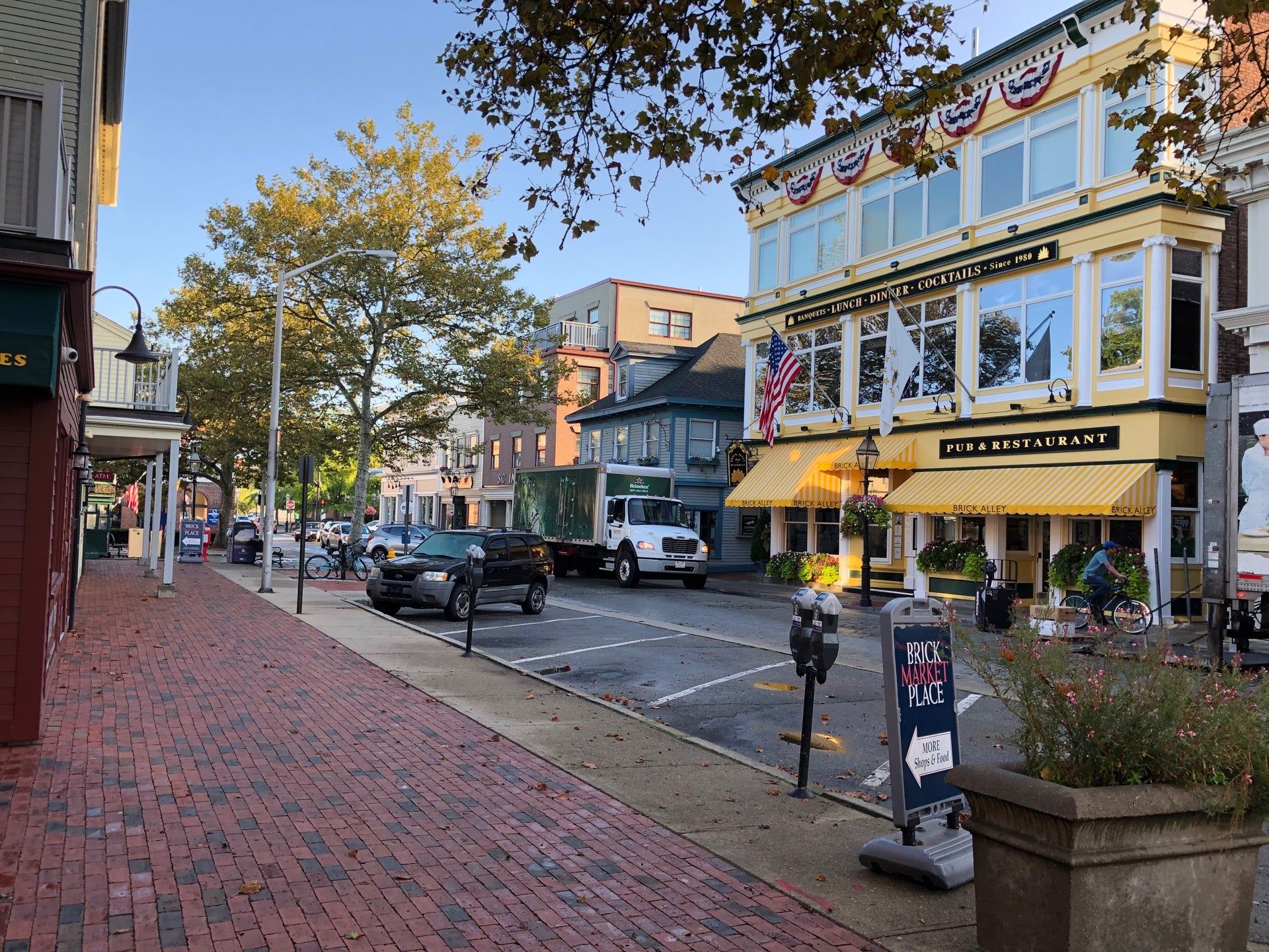 A brick sidewalk in a small town with a sign that says ' a ' on it