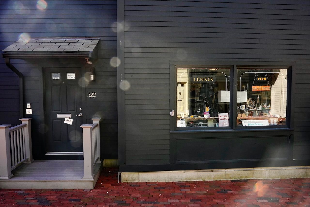A black building with a porch and a window.