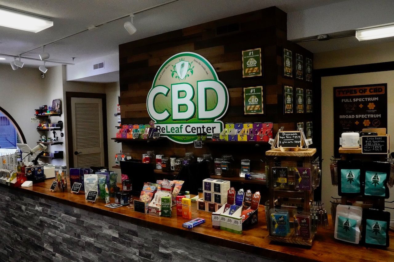 The inside of a store with a cbd sign on the wall.